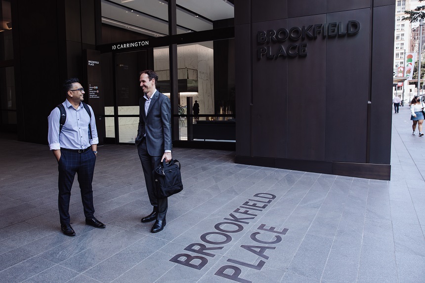 Two men in workwear standing outside of office